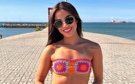 Key Alves em foto em frente à praia em Fortaleza, com biquíni de crochê, óculos de sol, sorrindo