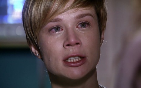 A atriz Mariana Ximenes como Lara em A Favorita; ela está chorando e olhando para o lado com cara de raiva