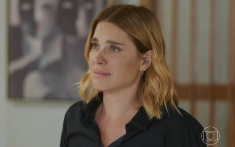 Em cena de Vai na Fé, Carolina Dieckmann usa blusa preta: ela está chorando enquanto fala com alguém