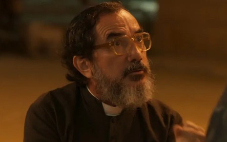 Nanego Lira com expressão séria em cena como padre Zezo na novela Mar do Sertão