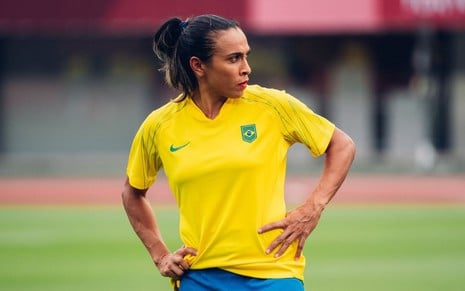 Marta coloca a mão na cintura durante aquecimento para jogo na Olimpíada de Tóquio; ela estava com uniforme do Brasil