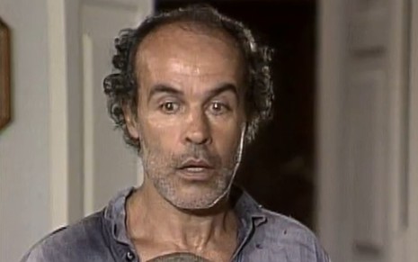 Osmar Prado com expressão assustada em cena como Tião Galinha na novela Renascer