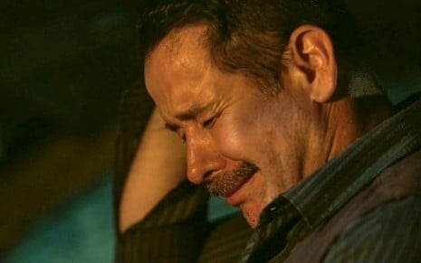 O ator Murilo Benício como Tenório em Pantanal; ele está com a mão ao lado da cabeça, olhando para baixo e chorando de olhos fechados