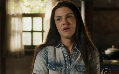 A atriz Paula Barbosa como Zefa em Pantanal; ela está olhando para o lado com cara de choro