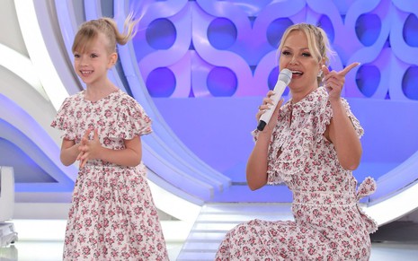 Manuela Ricco e Eliana Michaelichen no palco do programa Eliana, do SBT; elas usam vestidos floridos parecidos
