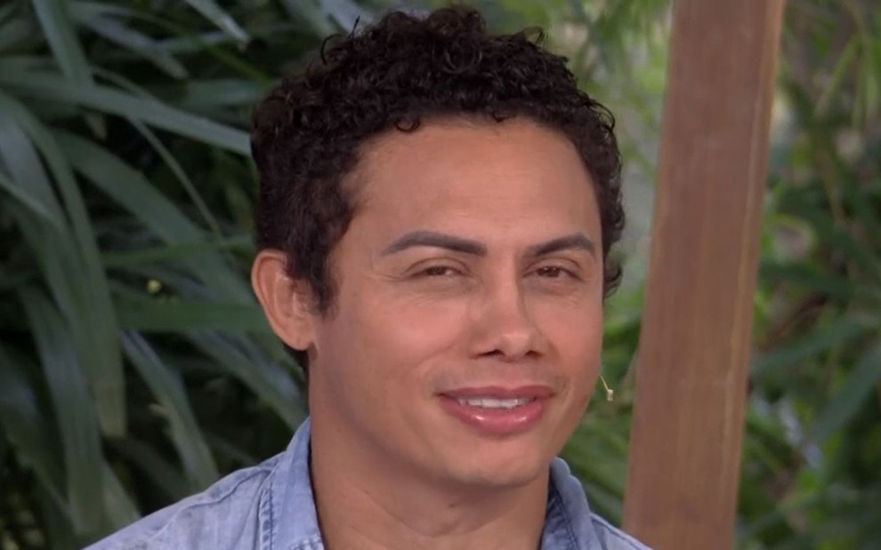 O ator Silvero Pereira durante participação no É de Casa, na Globo; ele está sentado, olhando para frente e sorrindo com cara de provocativo