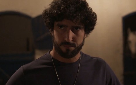 Renato Góes com expressão séria em cena como Tertulinho na novela Mar do Sertão