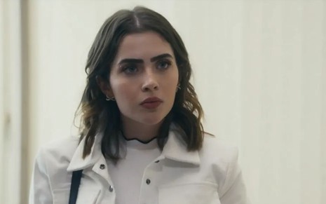 A atriz Jade Picon como Chiara em Travessia; ela está olhando ligeiramente para o lado com cara de espantada