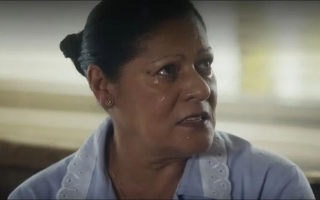 A atriz Luci Pereira como Creusa em Travessia; ela está olhando para o lado e chorando enquanto fala