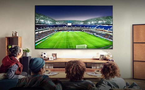 Amigos vendo jogo de futebol em uma TV 4K