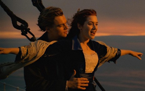 Leonardo DiCaprio segura Kate Winslet, que está de braços abertos em cena de Titanic