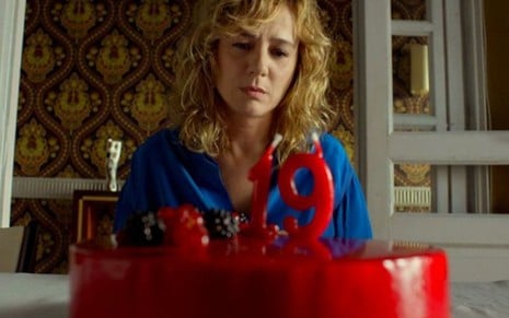 Emma Suárez como Julieta diante de um bolo vermelho com uma vela com o número 19 em cena do filme Julieta