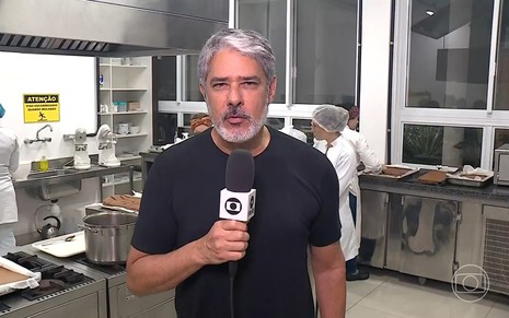William Bonner de camiseta preta apresentando o Jornal Nacional de dentro de uma cozinha