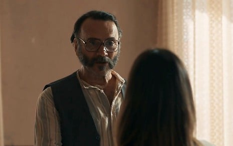 Em cena de Renascer, Almir Sater está conversando com Giullia Buscacio, que está de costas
