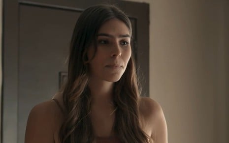 Gabriela Medeiros caracterizada como Buba; ela está séria em cena de Renascer