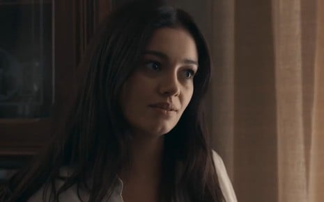 Sophie Charlotte caracterizada como Eliana; ela dá um sorriso sedutor em cena de Renascer