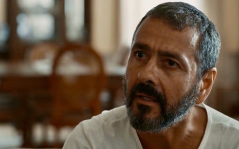 O ator Marcos Palmeira usa camisa branca e está com expressão de surpresa em cena da novela Renascer