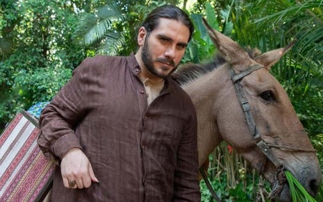 O ator Gabriel Sater está caracterizado como Rachid ao lado de um cavalo em foto de divulgação da novela Renascer