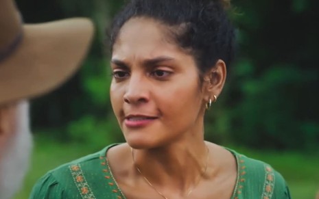 Barbara Reis usa uma blusa verde e exprime fúria em cena de Terra e Paixão
