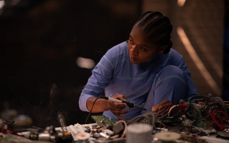 Dominique Thorne está trabalhando com solda em equipamentos eletrônicos em cena de Pantera Negra 2