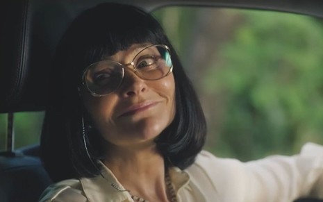 A atriz Alexandra Richter usa peruca e óculos em cena como Nice na novela Terra e Paixão