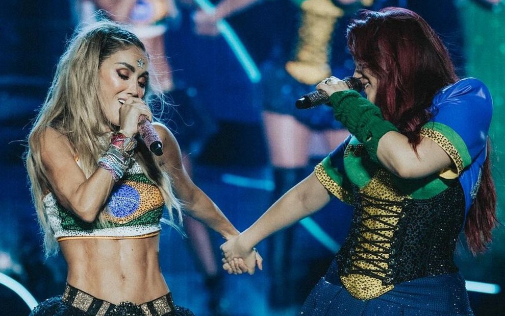 Mia Colucci e Dulce María estão de mão dadas, no show da banda RBD
