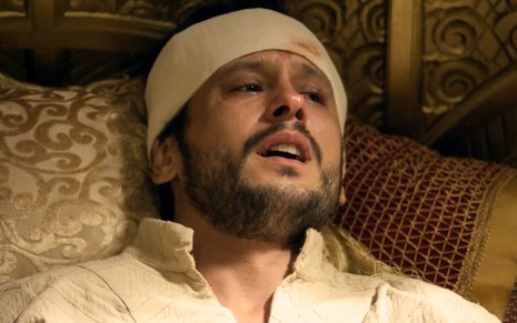 O ator Guilherme Dellorto como Salomão com esparadrapos sujos de sangue na cabeça em cena da novela Reis