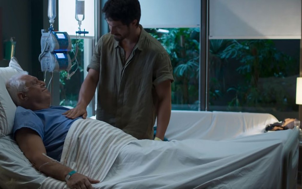 Alberto (Antonio Fagundes), moribundo na cama, recebe cuidados do filho Marcos (Romulo Estrela) em Bom Sucesso, novela das sete da Globo