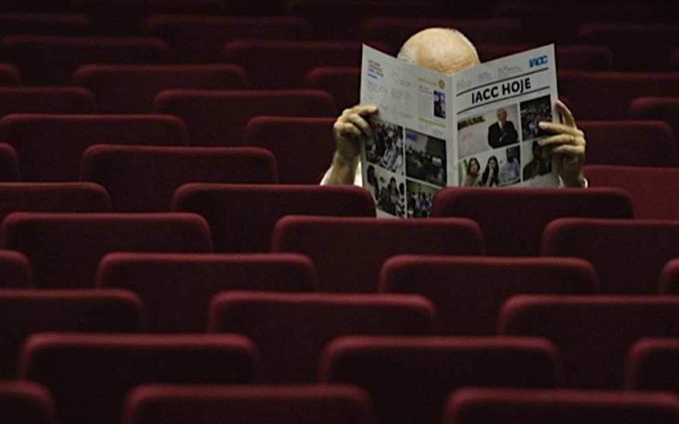 Homem lê jornal em auditório: mercado publicitário brasileiro atravessa um ano ruim - Reprodução