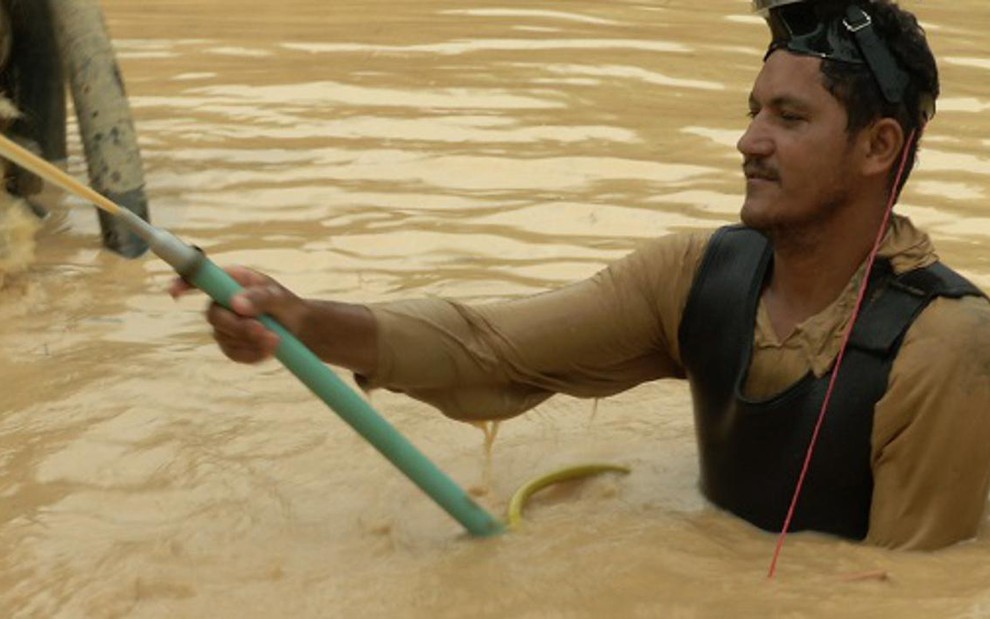 Garimpeiro entra em piscina de lama atrás de ouro no documentário A Nova Corrida do Ouro, do Discovery - Divulgação/Discovery