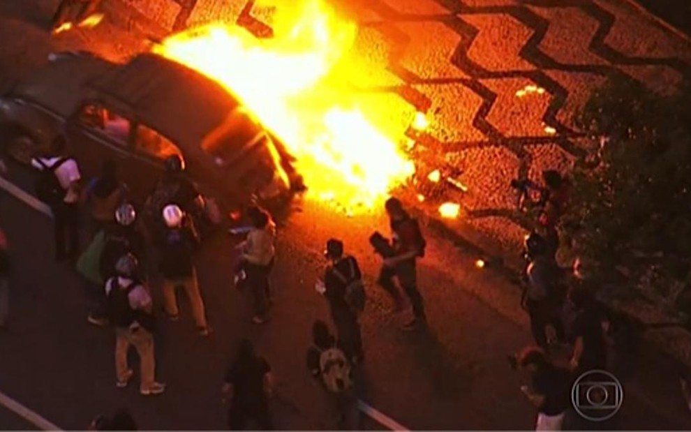 Manifestantes colocam fogo em Fusca em cobertura da Globo dos protestos contra a Copa no último dia 25 - Reprodução/TV Globo