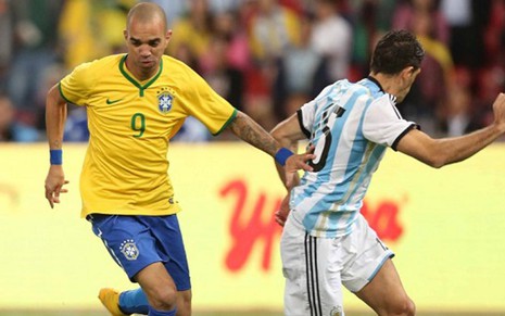O atacante brasileiro Diego Tardelli é marcado pelo zagueiro argentino Demichelis, no último sábado (11) - Rafael Ribeiro/CBF