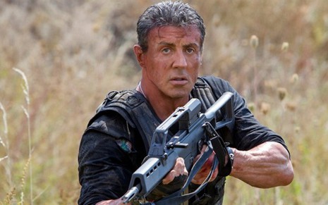 O ator Sylvester Stallone segura metralhadora em cena do filme Os Mercenários 3, de 2014 - Divulgação/Lionsgate