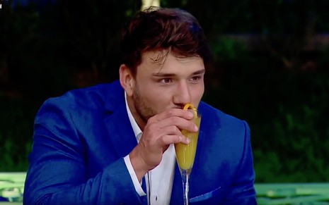O peão Lucas Viana bebe um drinque em festa do reality show A Fazenda