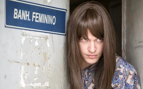 Alex (Caio Paduan) sai do banheiro feminino com roupas de mulher para fugir em Rock Story - Felipe Monteiro/TV Globo