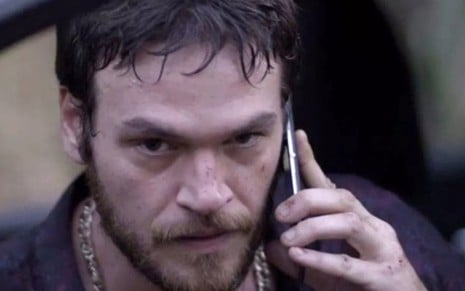 Após fugir pela mata, Rubinho (Emilio Dantas) marca reencontro com a mulher pelo celular - Divulgação/TV Globo