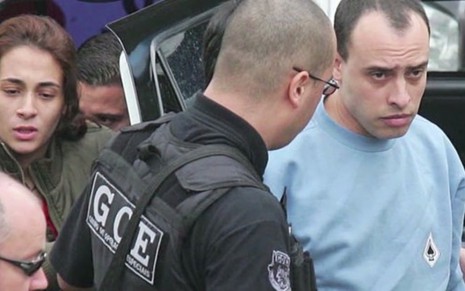 Alexandre Nardoni (de azul) é conduzido pela polícia em cena de Anatomia do Crime - Reprodução/Discovery