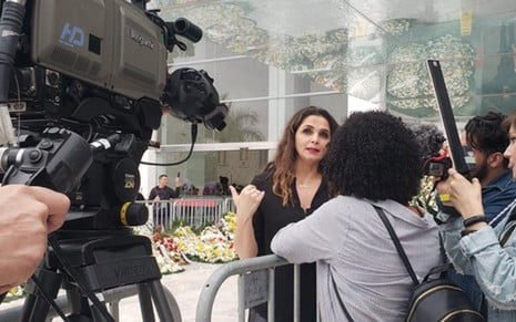 Luiza Ambiel concede entrevista a jornalistas na rampa de acesso  ao velório de Gugu Liberato