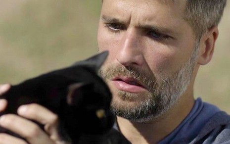 Gabriel (Bruno Gagliasso) segura o gato com poderes extraordinários em cena da novela das nove - REPRODUÇÃO/TV GLOBO