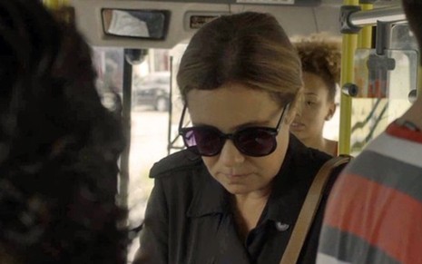 Laureta (Adriana Esteves) vai pegar dinheiro e entrar em ônibus sem ser vista por policiais - Fotos: Reprodução/TV Globo