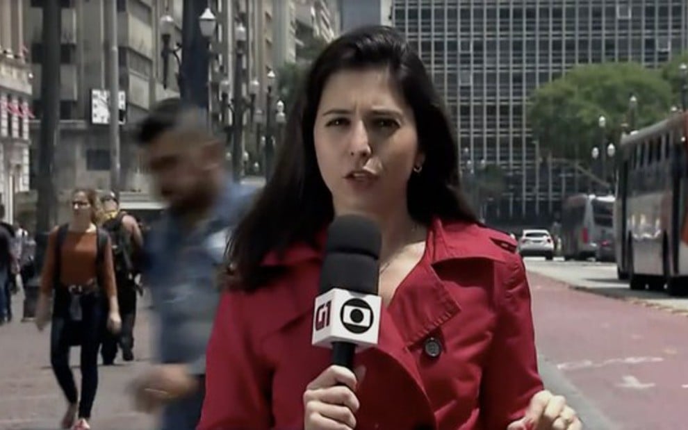 A repórter Cinthia Toledo com microfone com logotipos da Globo e do G1 no SP1 de terça (17) - Reprodução/TV Globo