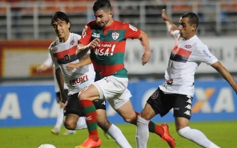 Guilherme, atacante da Lusa, passa por defensores do Brasil de Pelotas em jogo da Série C - Dorival Rosa/Portuguesa