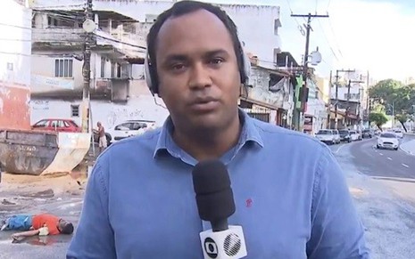 O repórter Vanderson Nascimento, com cadáver ao fundo, durante telejornal da Globo da Bahia - Reprodução/Rede Bahia