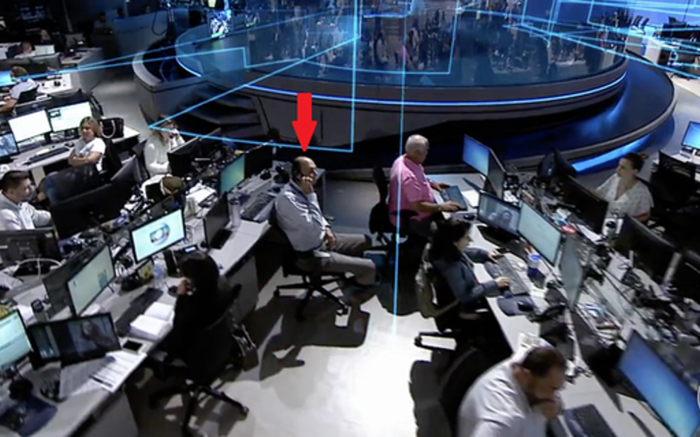 Diretor-executivo de jornalismo da Globo, Mariano Boni (seta) faz figuração no JN de terça (19) - Imagens: Reprodução/TV Globo
