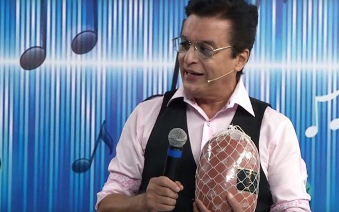 No Programa do Nahim, o cantor segura uma mortadela, prêmio do quadro A Palavra no Saco - Reprodução/Rede Brasil
