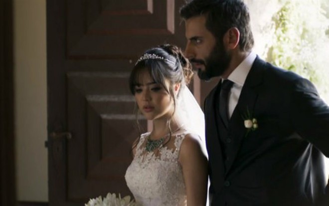 Vinícius (Flávio Tolezani) conduz Laura (Bella Piero) ao altar em O Outro Lado do Paraíso - Reprodução/TV Globo