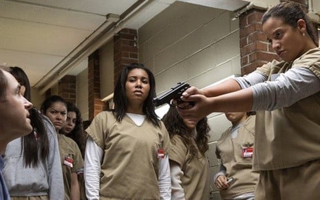 A atriz Dascha Polanco (à dir) aponta arma para Michael Torpey na 5ª temporada de Orange - Fotos: Divulgação/Netflix