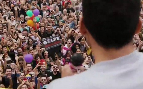 Miguel Ángel Silvestre olha para cartaz anti-Globo em cena gravada na avenida Paulista - Fotos: Divulgação/Reprodução/Netflix