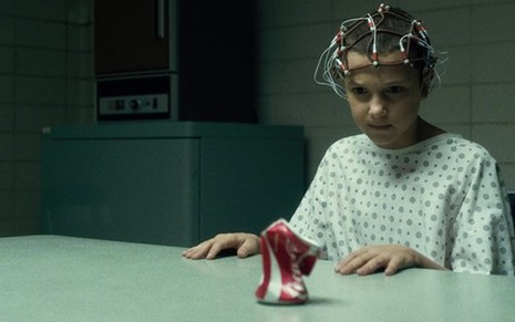Millie Bobby Brown em Stranger Things; latinha de Coca-Cola amassada com o poder da mente e da grana - Divulgação/Netflix