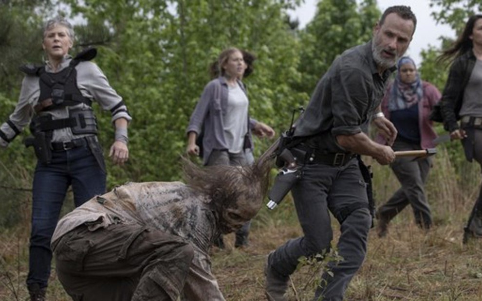 Observado por Carol (Melissa McBride), Rick (Andrew Lincoln) ataca zumbi em Walking Dead - Divulgação/AMC